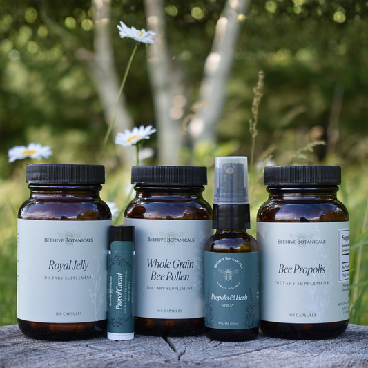 Health and Wellness Supplement bottles from Behive Botanicals on a wooden surface with a natural background