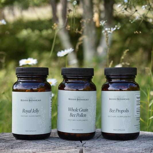 Vitality bundle of Beehive Botanicals dietary supplements on a wooden surface with a natural background.